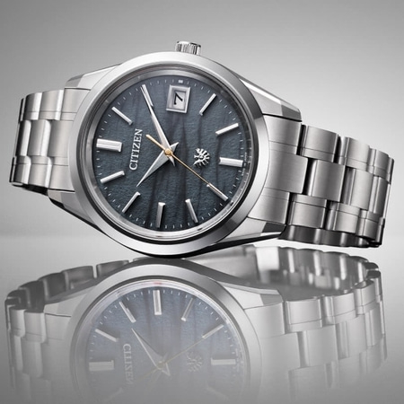 Citizen-Uhr mit dunklem Zifferblatt und silbernem Armband, elegantes Design.