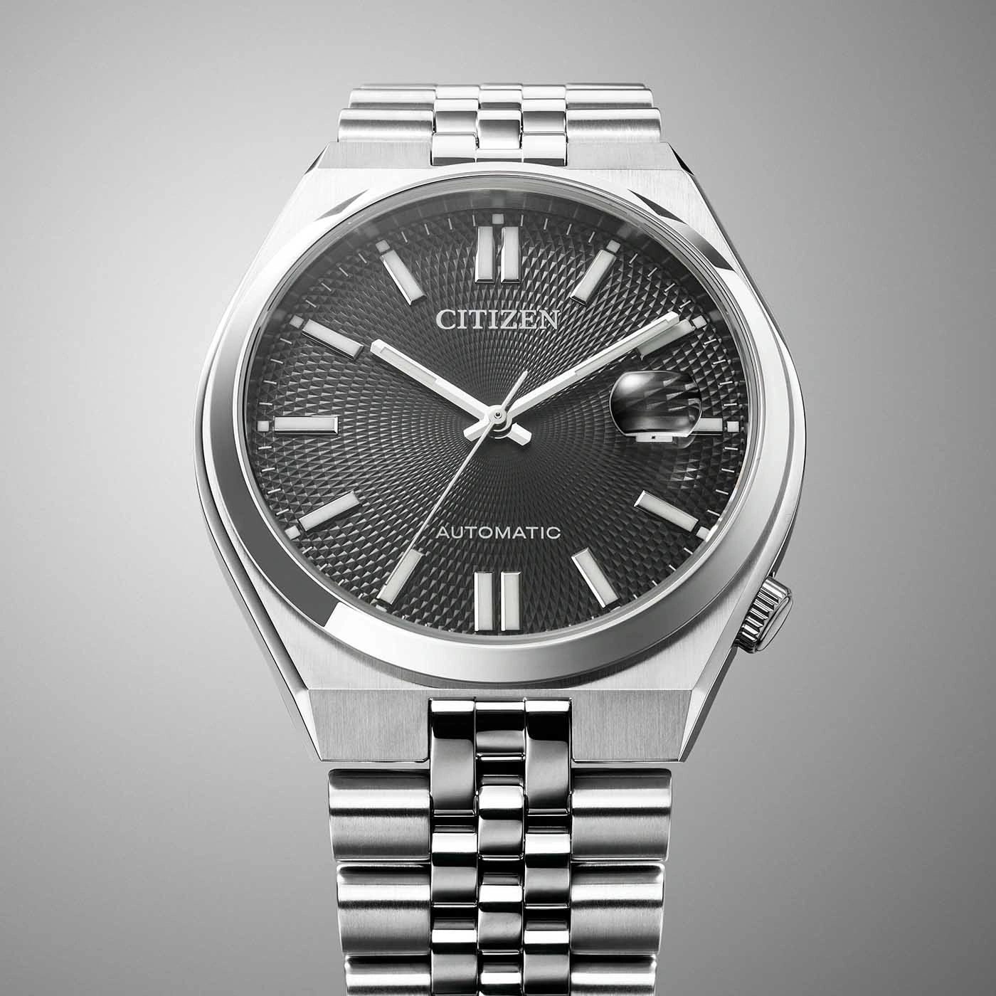 Une montre-bracelet Citizen automatique argentée avec un cadran texturé gris foncé.