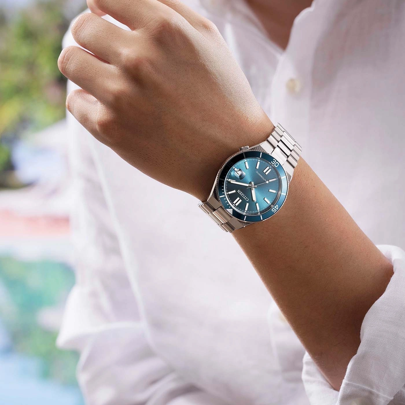 Ein Mann trägt eine blaue Citizen-Uhr am Handgelenk.
