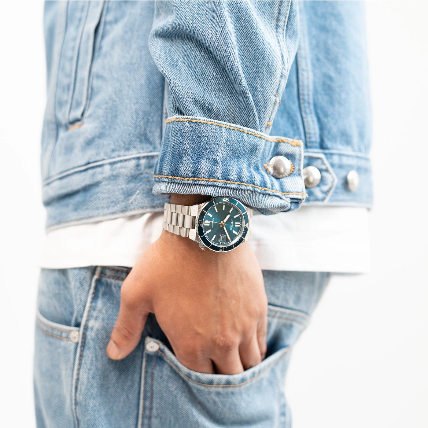 Mann trägt eine Jeansjacke und eine blaue Citizen-Uhr.