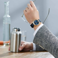 Homme portant une montre, des lunettes et une bouteille d'eau, tenue de travail