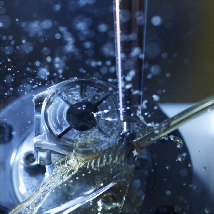 Nahaufnahme einer Werkzeugmaschine mit Wasserspritzern, industrieller Prozess.