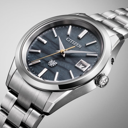 Citizen-Uhr mit dunkelblauem Zifferblatt und silbernem Armband, elegantes Design.