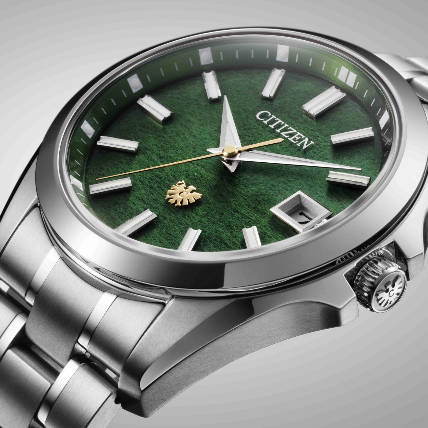 Citizen-Uhr mit grünem Zifferblatt, Silberarmband und goldenem Logo.