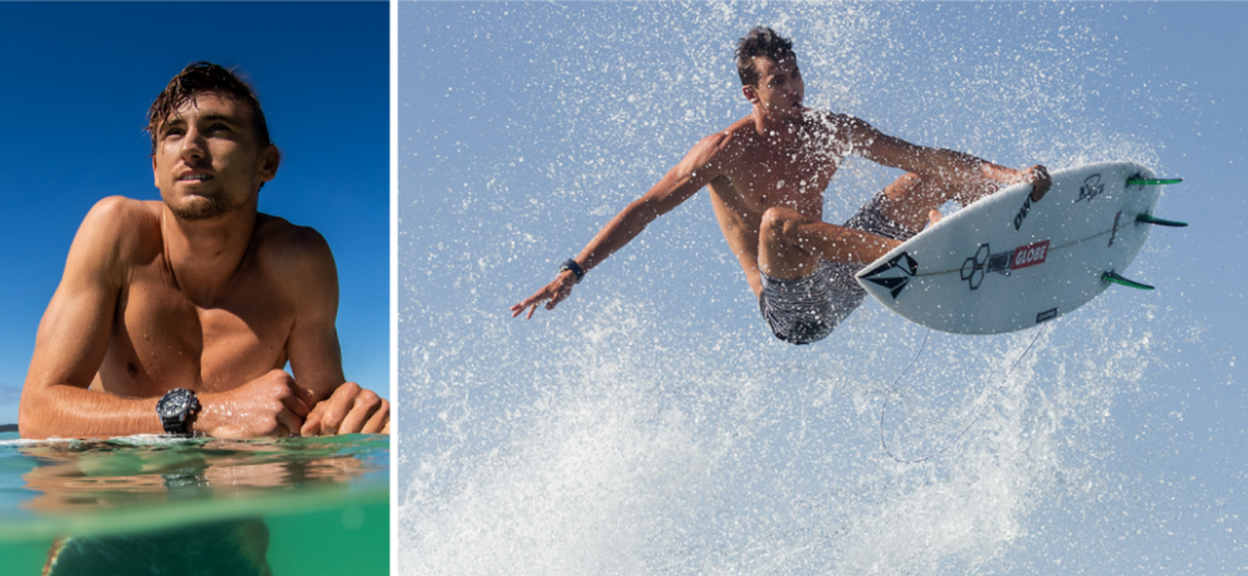 Surfer in Aktion, in der Luft, mit Surfbrett und Wasserspritzern vor blauem Himmel.