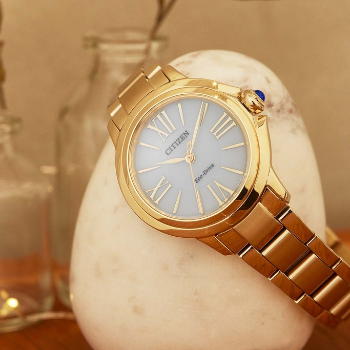Goldene Citizen-Uhr auf einem weißen Stein, elegantes und stilvolles Design.