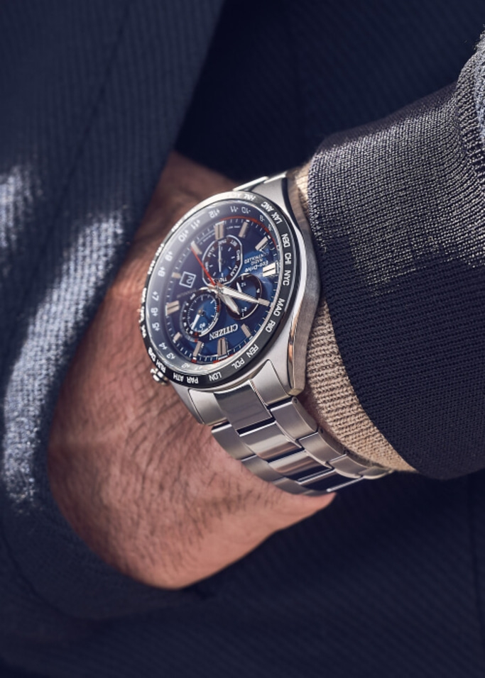 Gros plan d'une montre Citizen au poignet, avec un cadran bleu et un bracelet argenté.