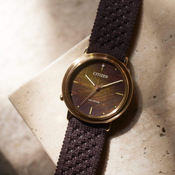 Montre Citizen avec bracelet marron et cadran doré, technologie Eco-Drive.