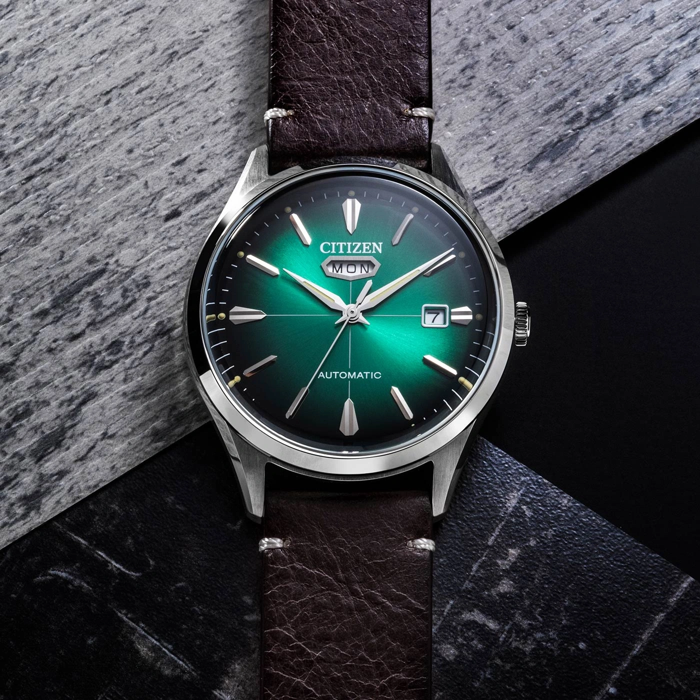 Eine grüne Citizen Automatik-Uhr auf dunklem, texturiertem Hintergrund.