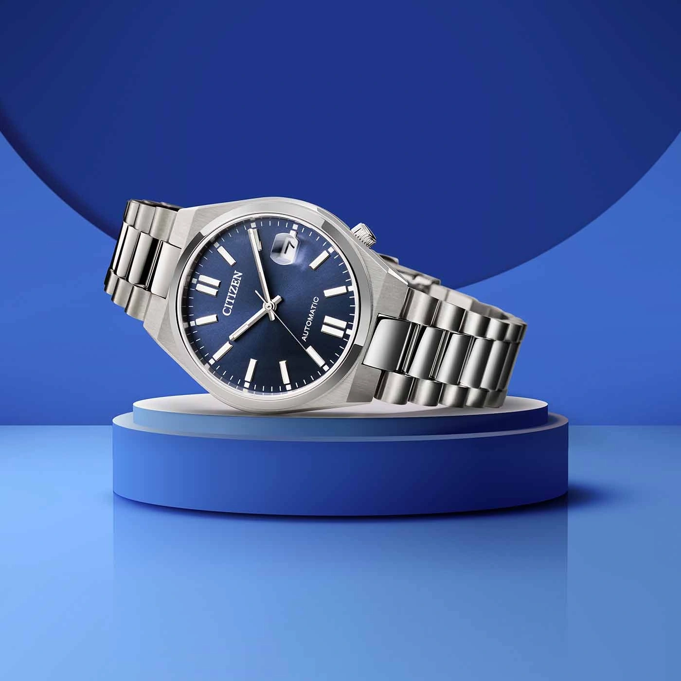 Une montre argentée de marque Citizen avec un cadran bleu sur un présentoir bleu.