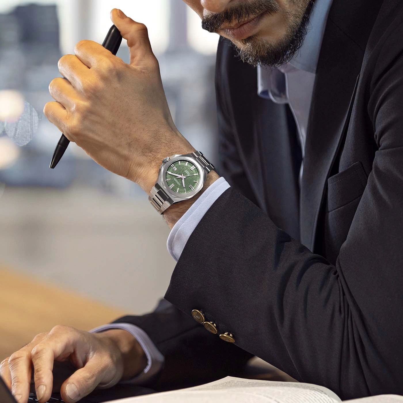 Ein Geschäftsmann trägt eine grüne Uhr am Handgelenk.