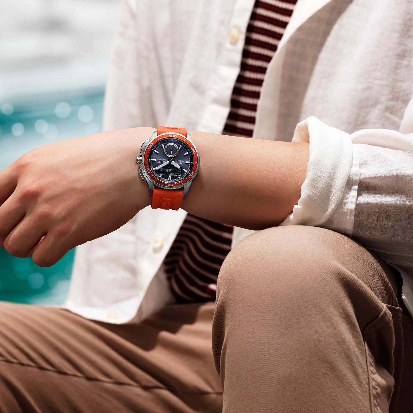 Homme portant une montre Citizen Eco-Drive orange au poignet.