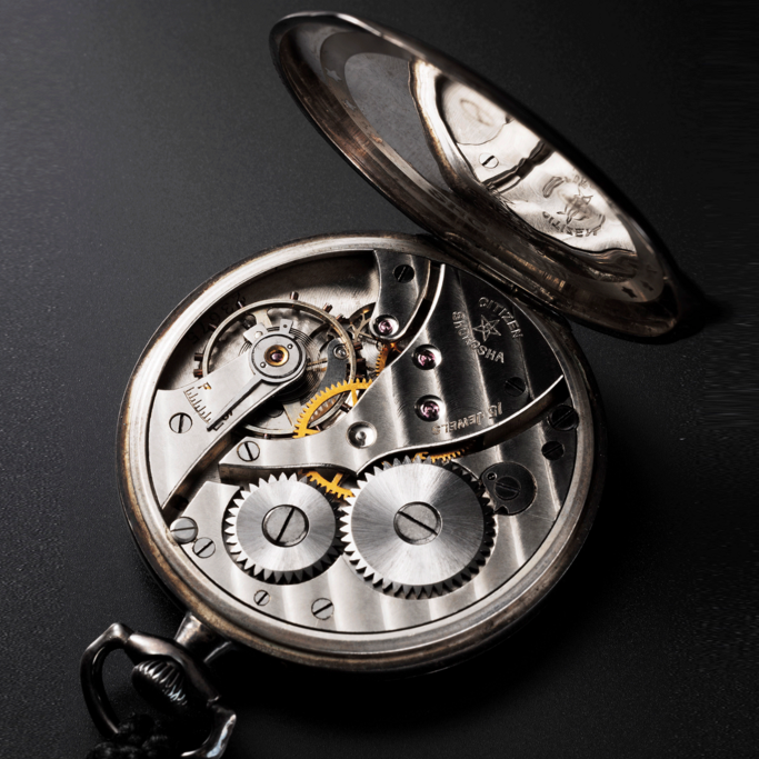 Gros plan d'une montre de poche Citizen Shokosha avec des engrenages et des détails complexes.