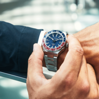 Mann schaut auf seine Citizen Automatik GMT Uhr mit rot-blauer Lünette.