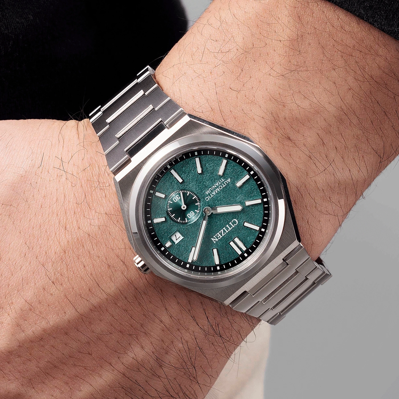 Eine Citizen Automatik-Uhr aus Titan mit grünem Zifferblatt am Handgelenk