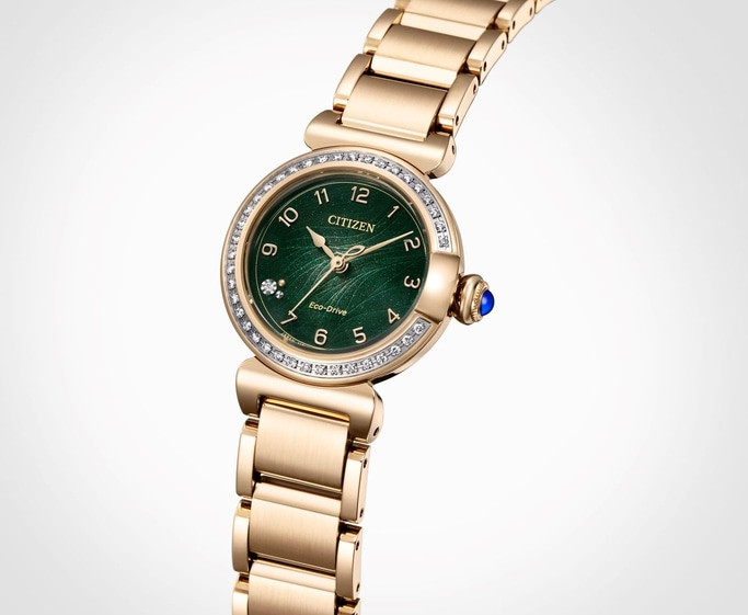 Goldene Citizen-Uhr mit grünem Zifferblatt und Diamantakzenten, elegantes Design.