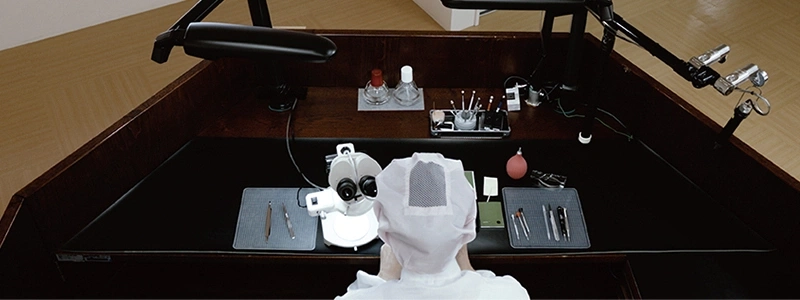 Une table de travail avec un microscope et des outils pour la réparation de montres.