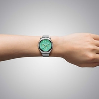 Le poignet d'un homme portant une montre chronographe Citizen verte.