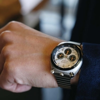 Le poignet d'un homme portant une montre chronographe Citizen argentée.