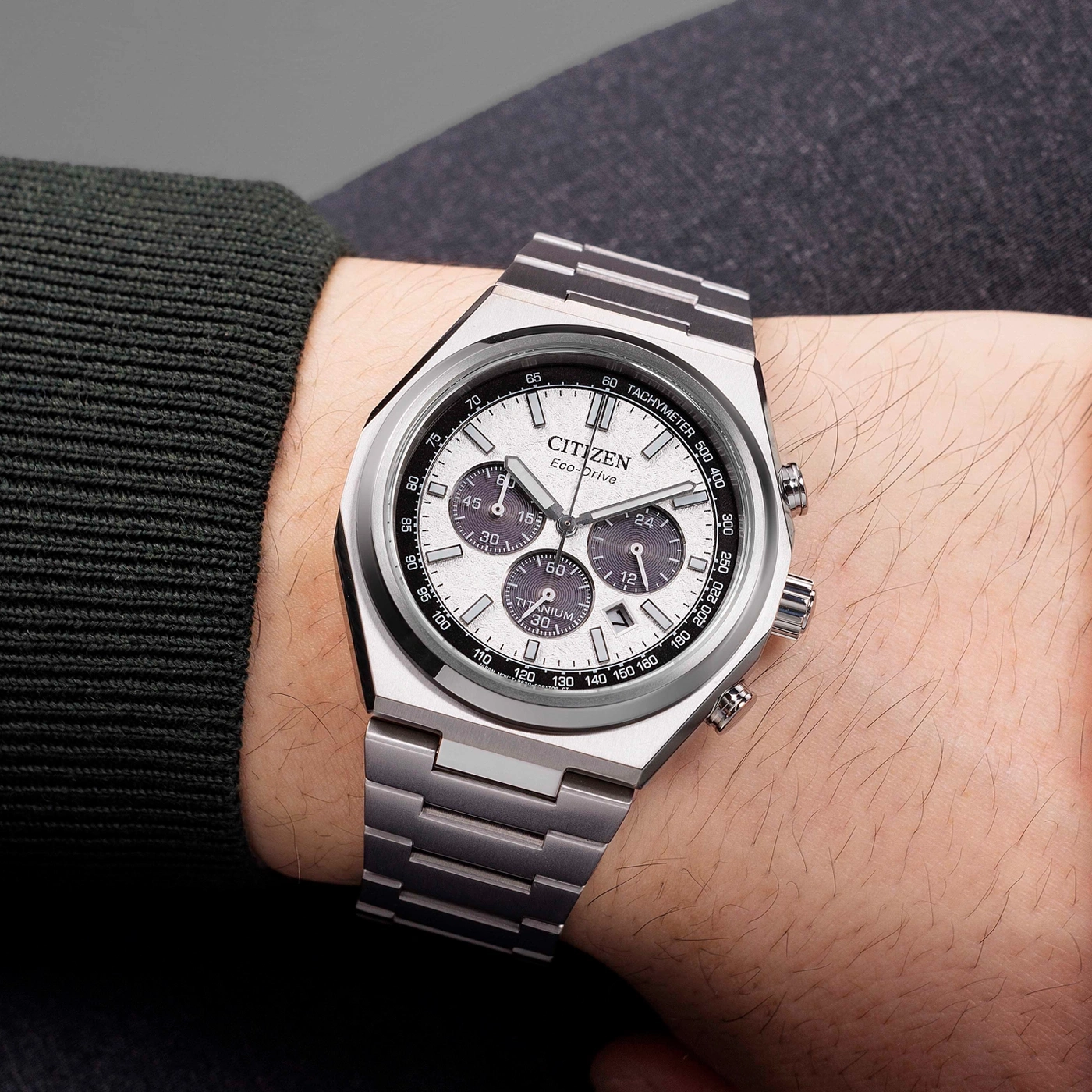 Citizen Eco-Drive Titanuhr an einem männlichen Handgelenk mit dunklem Pullover.