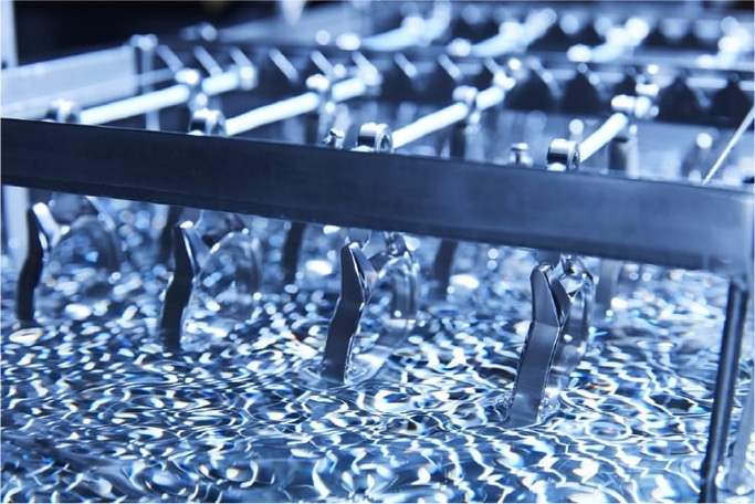 Metallteile werden in Flüssigkeit getaucht, industrieller Prozess, Nahaufnahme.