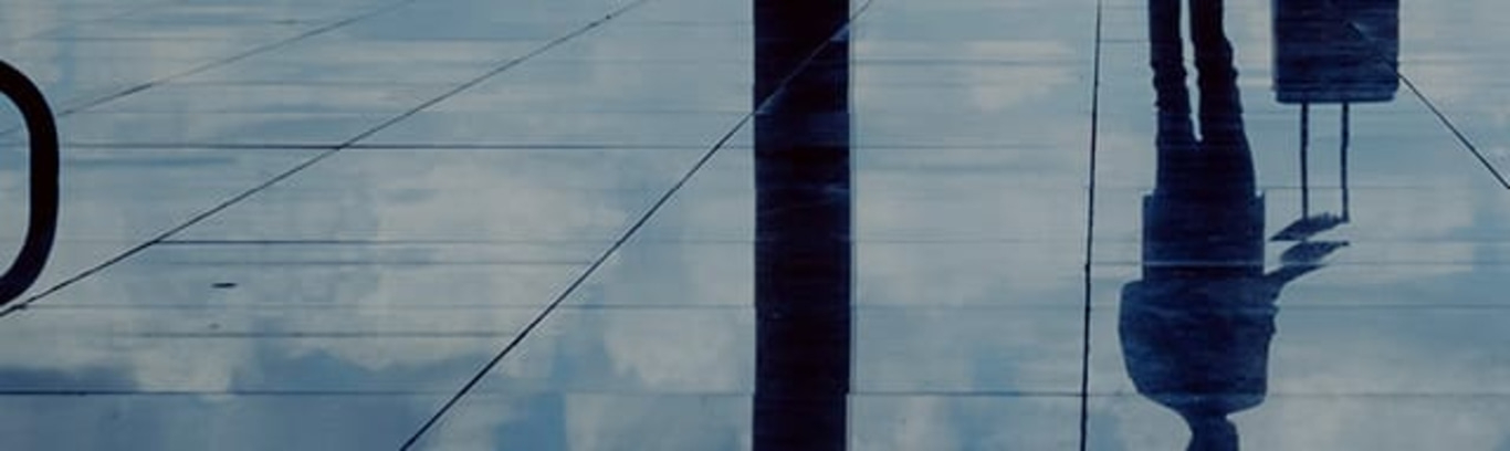 Reflexion einer Person auf Glas, abstrakt und künstlerisch dargestellt.