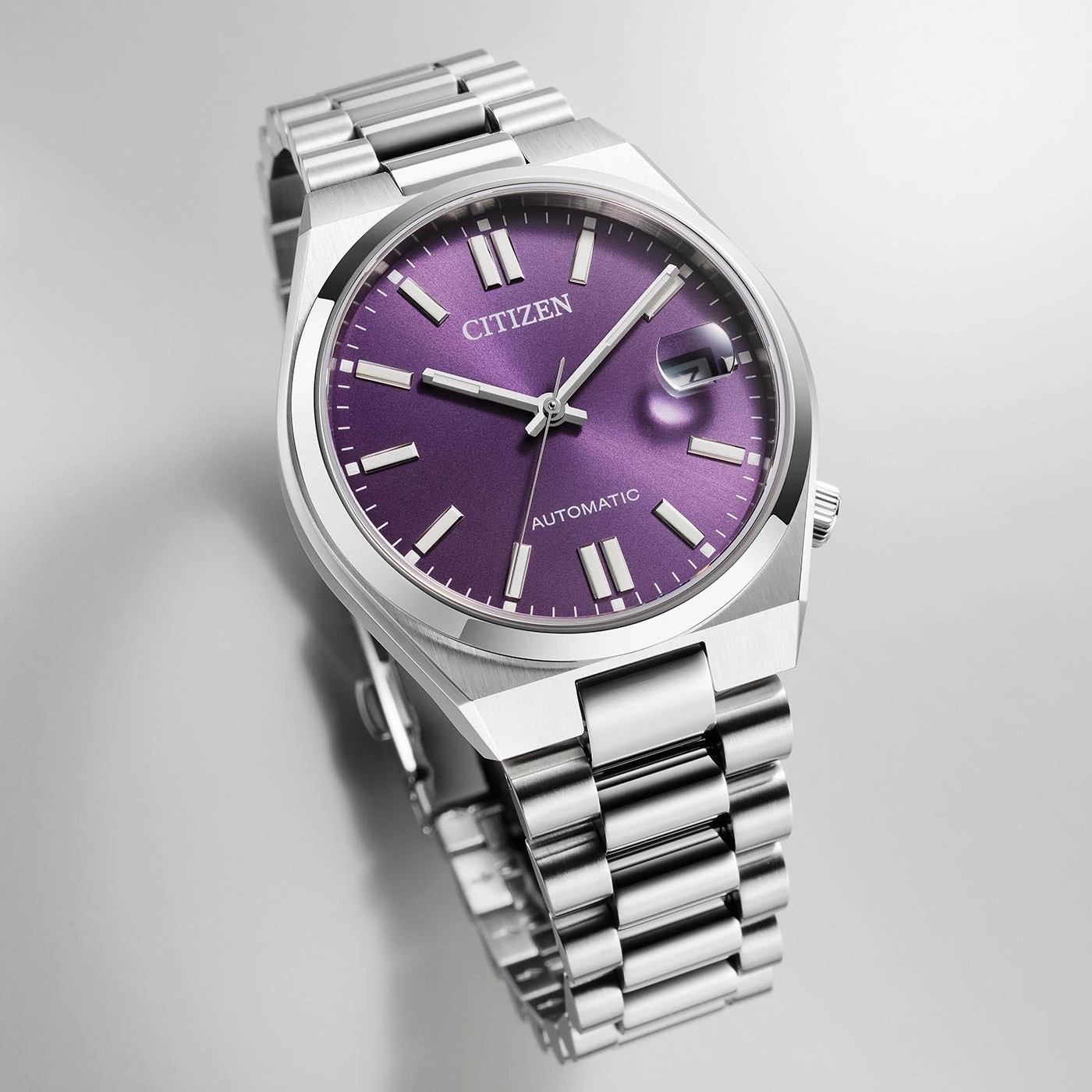 Montre Citizen automatique avec cadran violet et bracelet en argent.