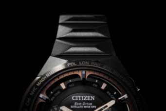 Nahaufnahme einer Citizen-Uhr mit Text, schwarzem und kupferfarbenem Design, Satellitenwelle.