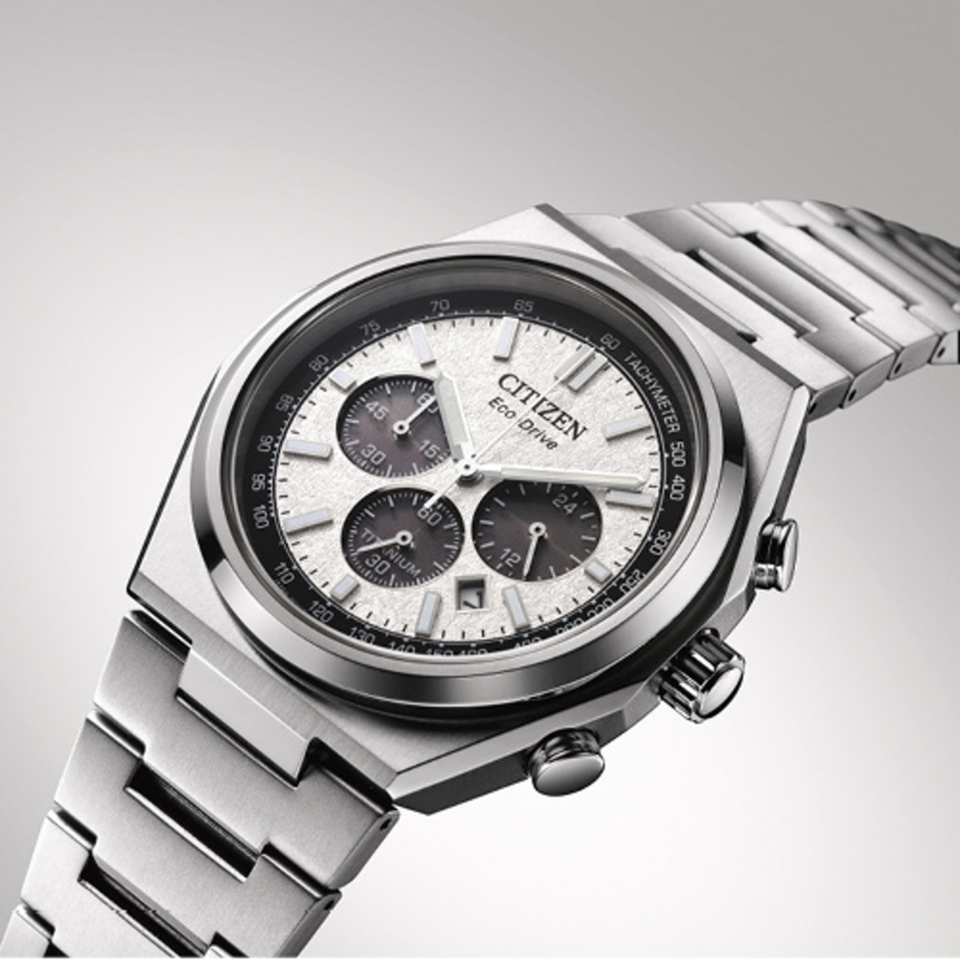 Silberne Citizen Eco-Drive Chronograph-Uhr auf hellgrauem Hintergrund.