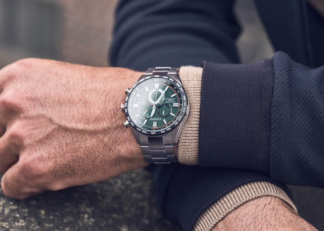 Homme portant une montre Citizen avec un cadran vert et un bracelet argenté.