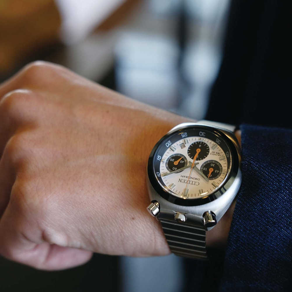 Le poignet d'un homme portant une montre chronographe Citizen argentée.