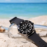 Montre Citizen automatique sur une plage avec une bouteille à message