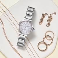 Une collection de bijoux élégants comprenant une montre Citizen, des boucles d'oreilles et des bagues.