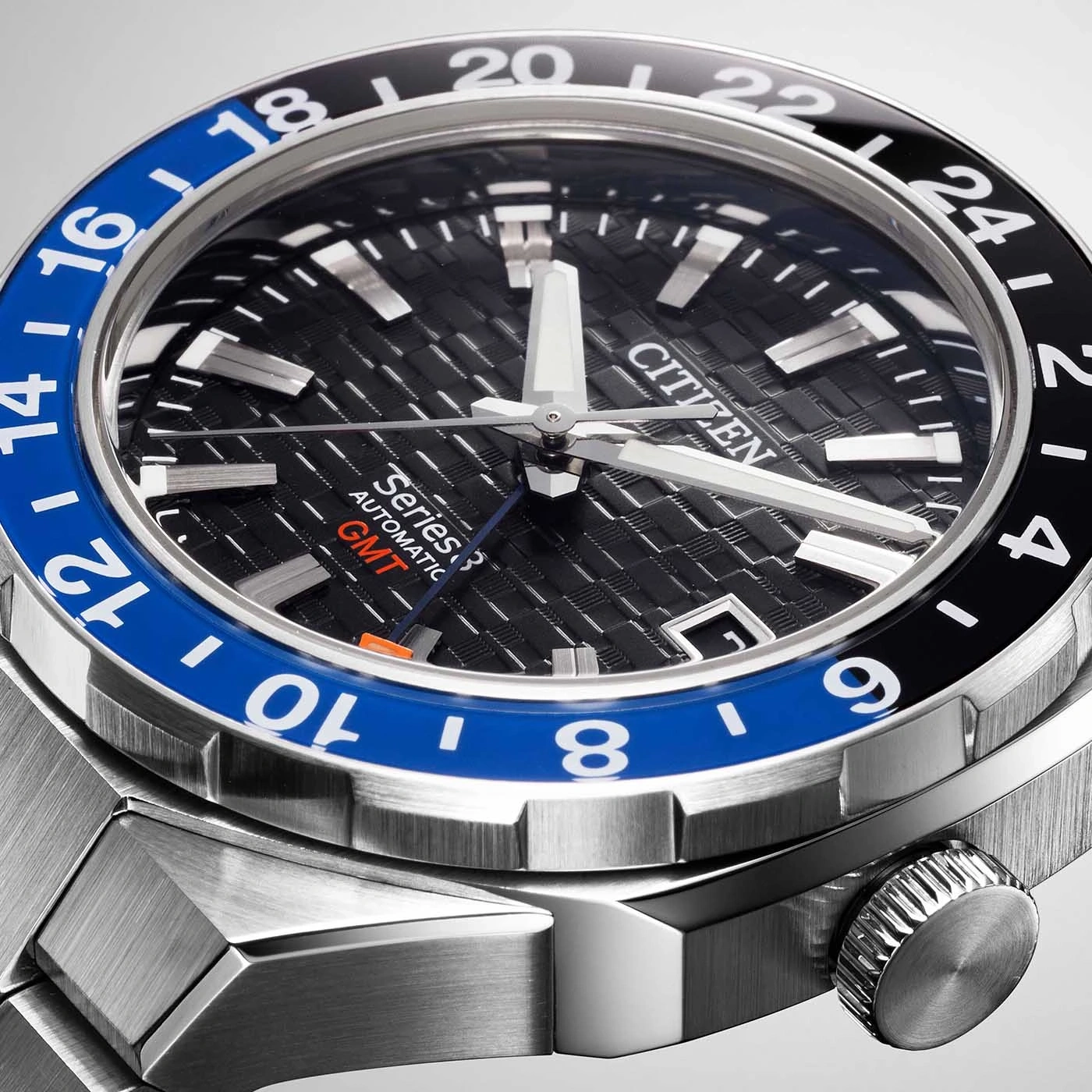 Close-up of a Citizen watch with a black and blue bezel and a textured dial.