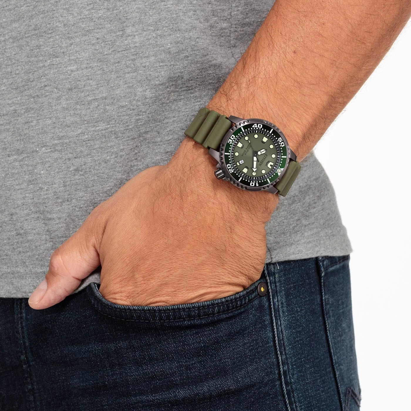 Ein Mann trägt eine grüne Armbanduhr mit Kautschukarmband.